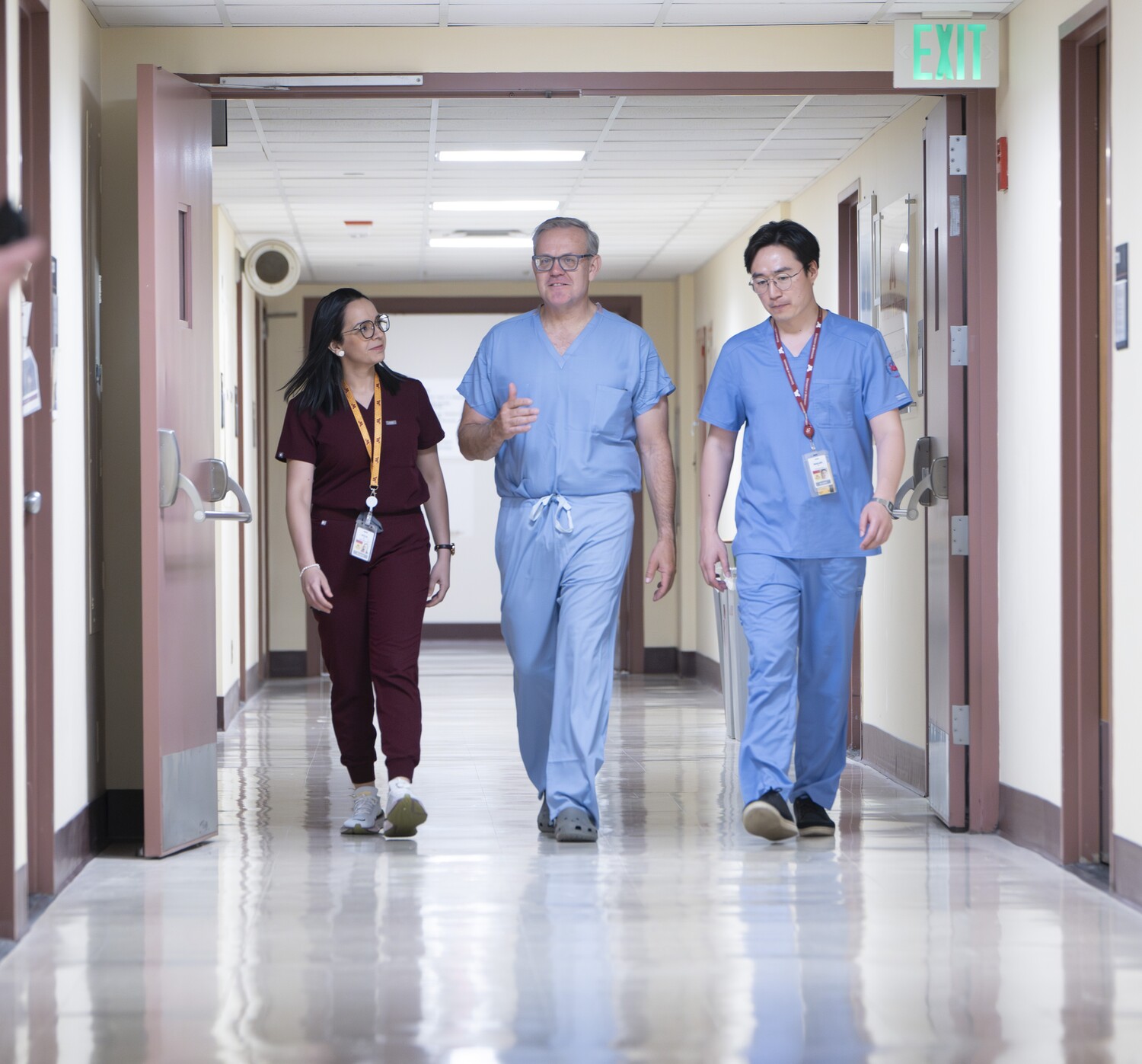 a photo of Alicia Cerrato Grande, Todd Tuttle, and Batsukh Pushkin walking down a hospital hallway