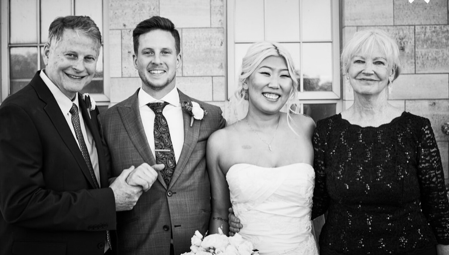 photo of Lily Taylor on her wedding day, posing with her husband, Kevin, and her parents