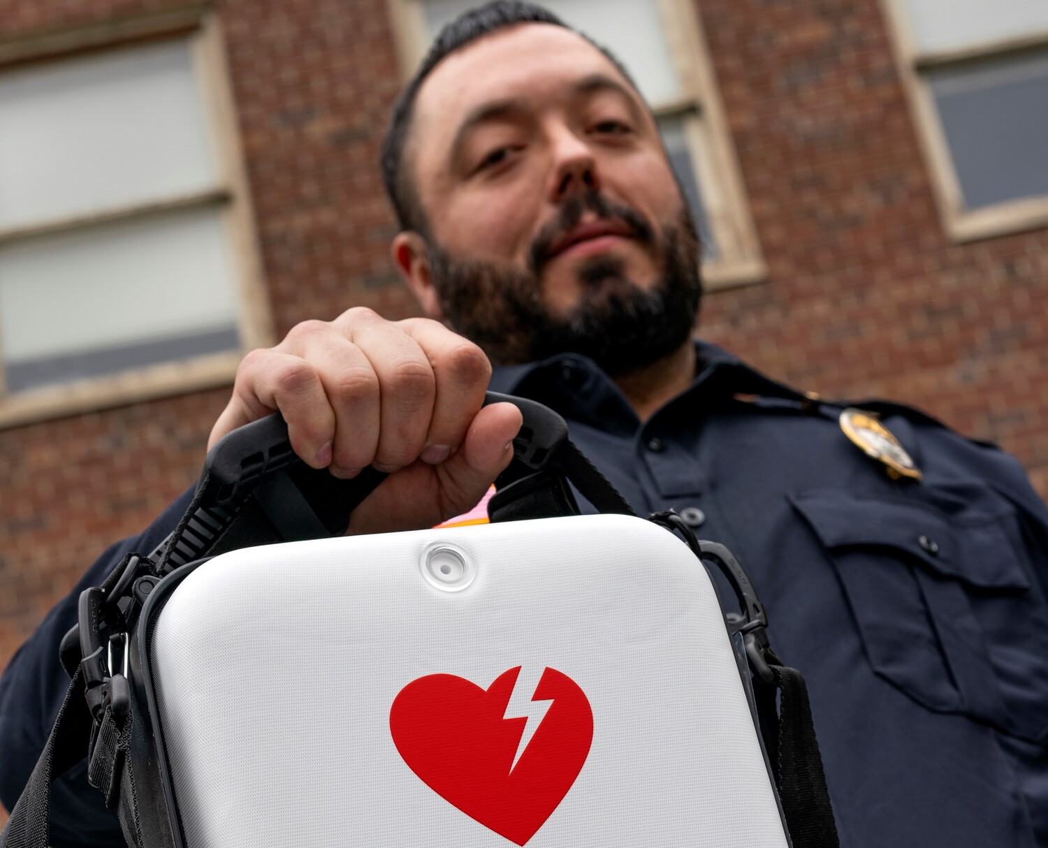 A police officer holds up an automated external defibrillator kit