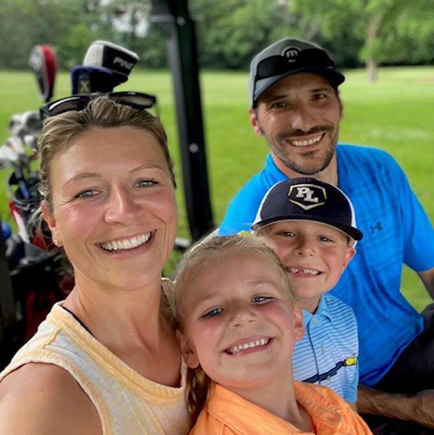 Amy Crnecki smiles while sitting in a golf cart with her family