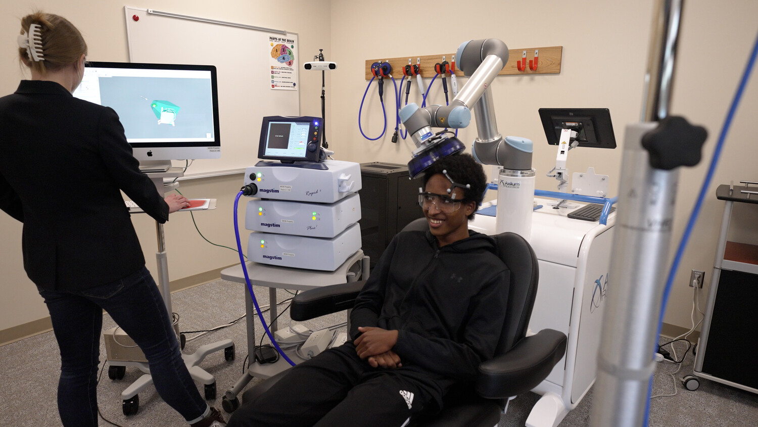 A researcher at the Masonic Institute for the Developing Brain uses transcranial magnetic stimulation technology with an adolescent