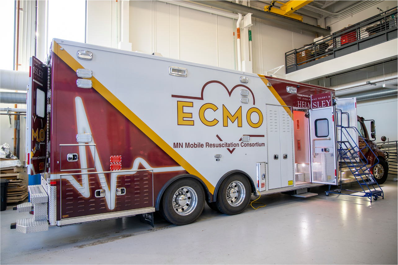 The maroon, gold, and white mobile ECMO truck is about the size of a large semi trailer.