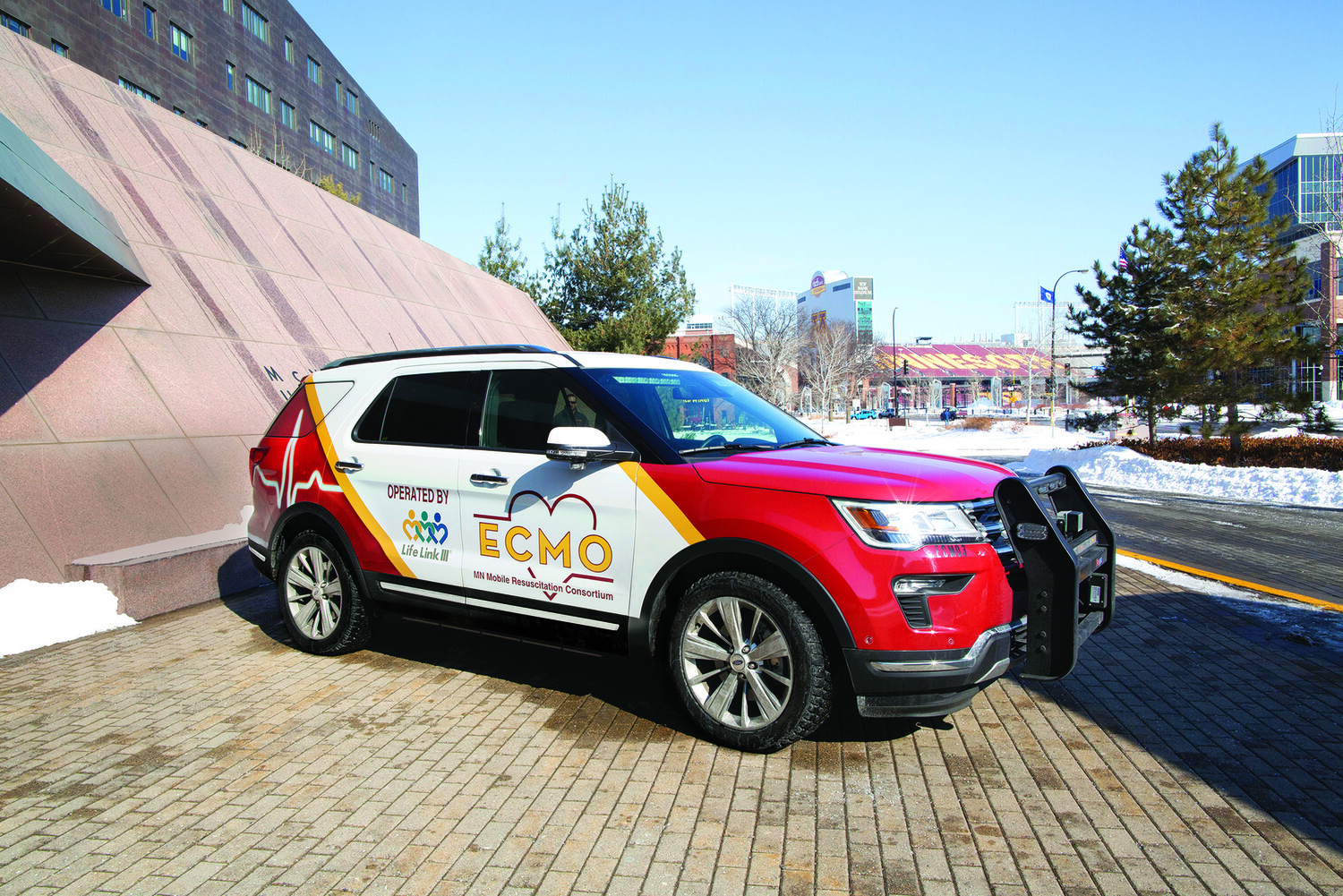 A maroon and gold ECMO-equipped SUV parked at the U of M Twin Cities campus
