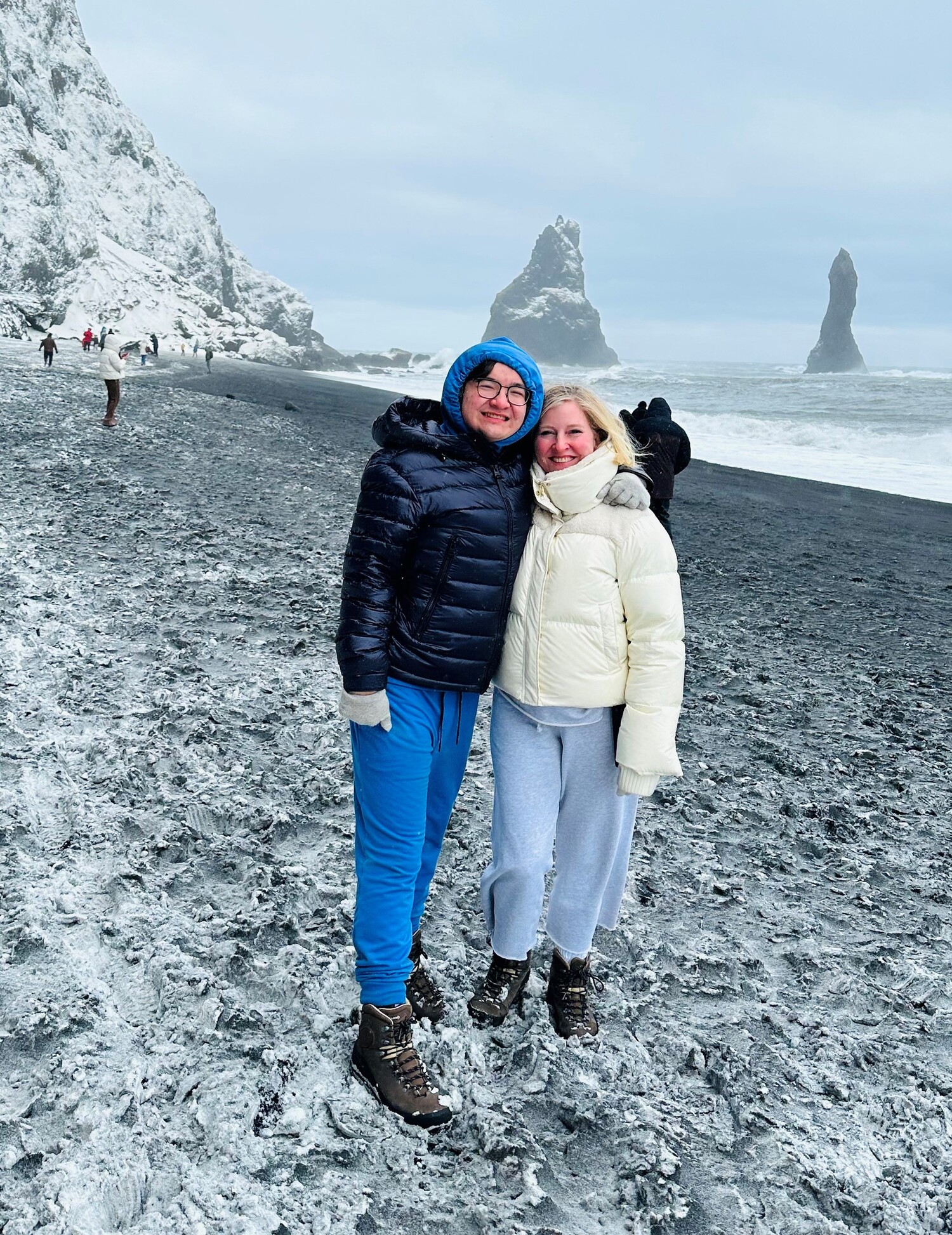 Ethan Li with his arm around his mom, Jeanne Farley, wearing winter clothes on a frost-covered beach