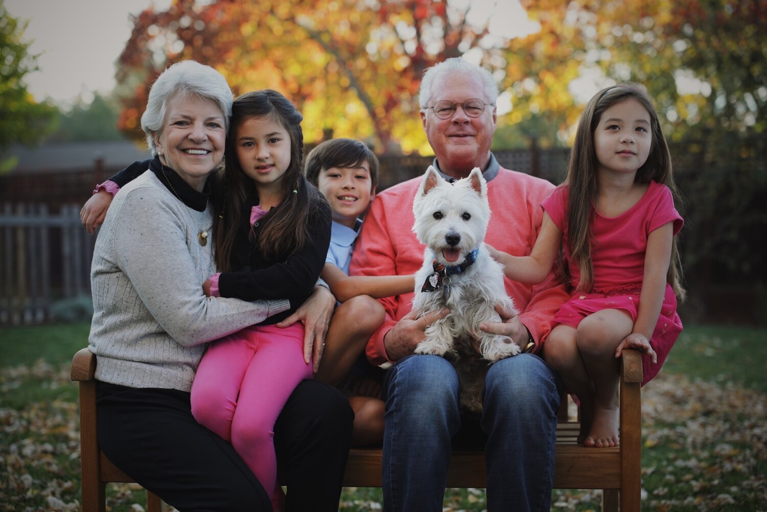 a photo of Julie and Ted Meek sitting with their three grandchildren and dog