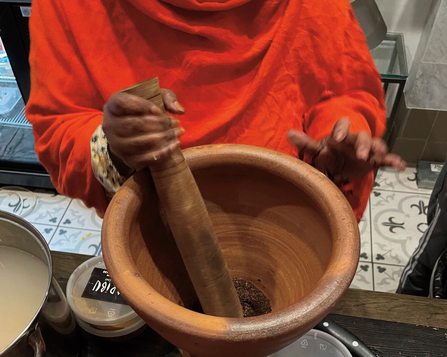 a pair of hands mixes ingredients in a large wooden bowl