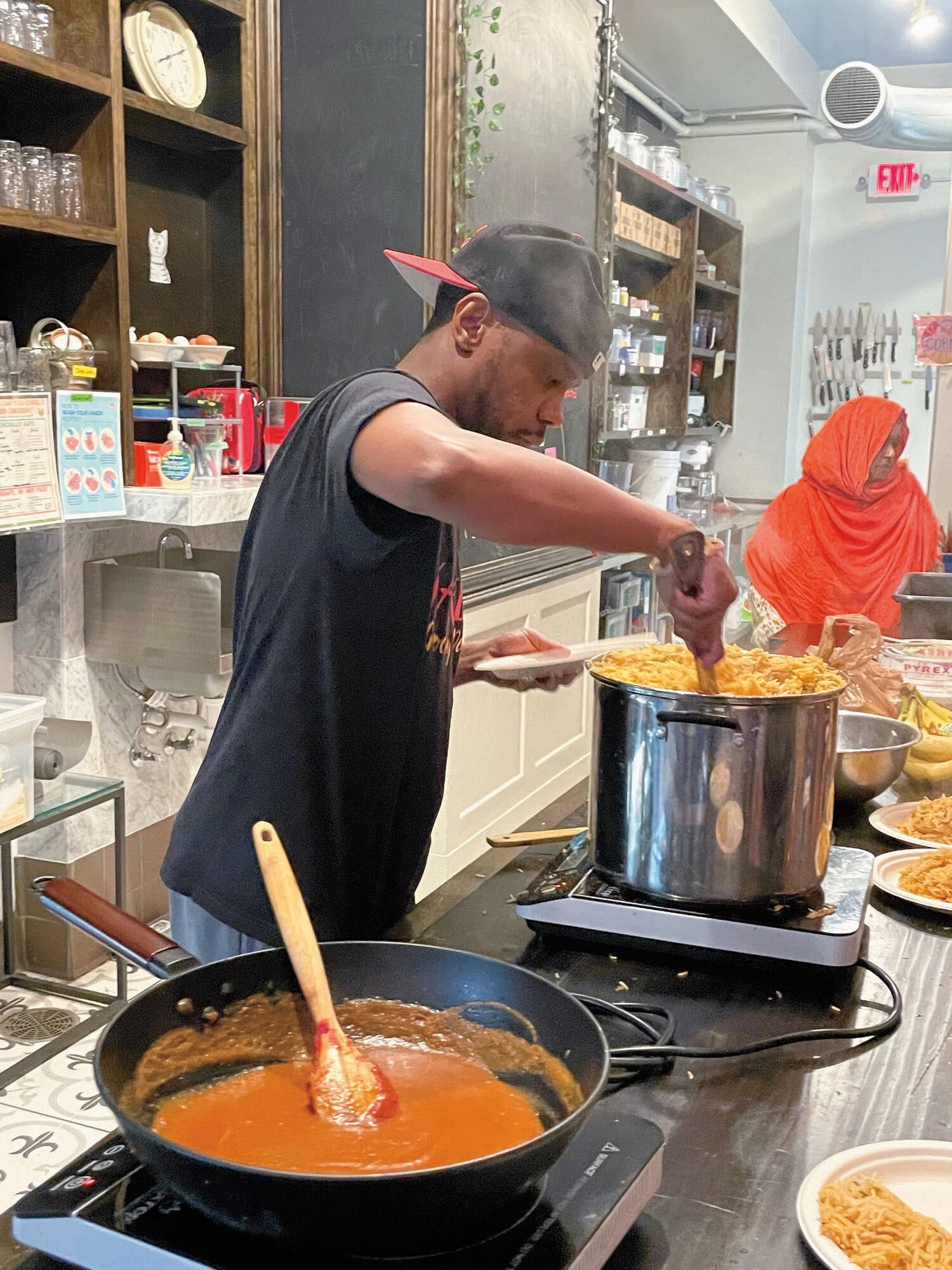 a man stirs a large pot of noodles